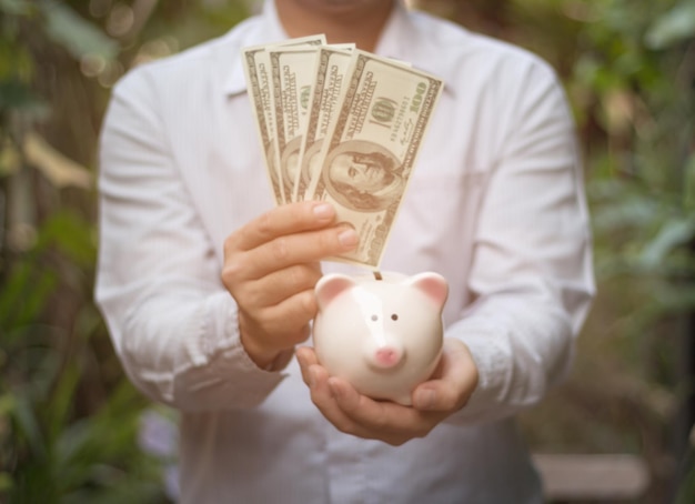 man holding money and piggy bank