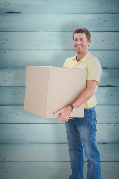 Man holding moving boxes against wooden planks