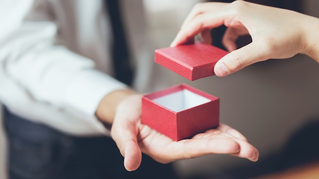 Man holding open the empty red gift box.