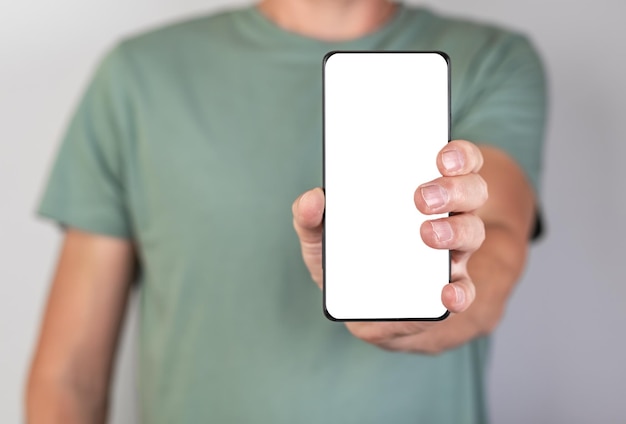 Man holding phone mockup in vertical position blank display Person stretching smartphone forward for showing smth