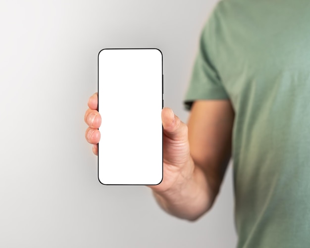 Man holding phone mockup in vertical position Person using smartphone for showing photo or information empty screen