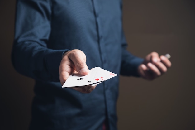 Photo man holding playing cards on brown surface