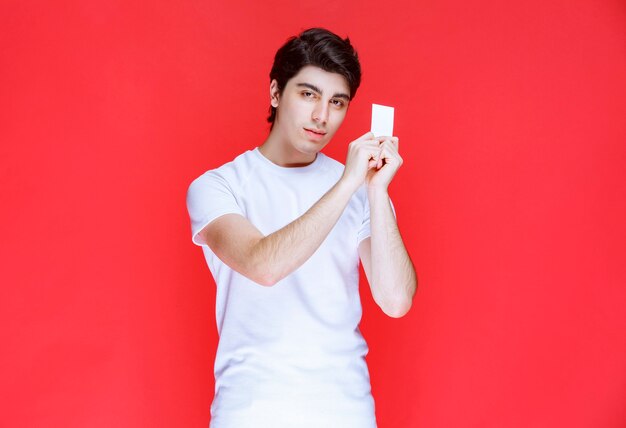 Man holding and presenting his business card. 