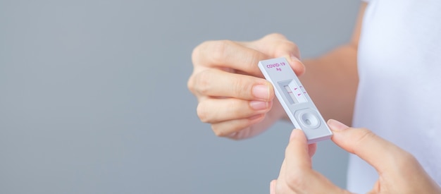 Man holding Rapid Antigen Test kit with Negative result during swab COVID-19 testing. Coronavirus Self nasal or Home test, Lockdown and Home Isolation concept