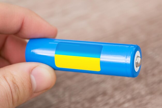 Man holding rechargeable liion battery with flag of Ukraine