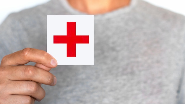 Man holding a red cross sign The male Red Cross Red Cross The medicine Help