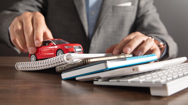 Man holding red toy car over business objects