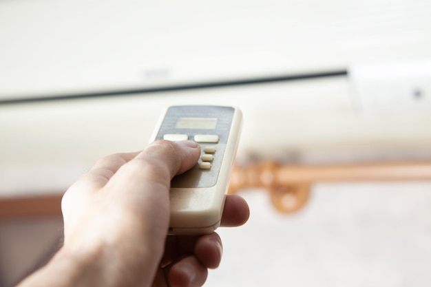 Man holding a remote control from the air conditioner