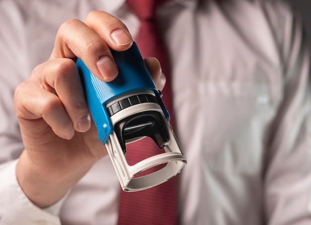 Man holding rubber stamp close up. Businessman certify documents.