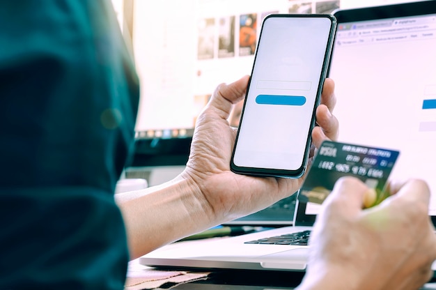 Man holding smartphone and credit card for shopping online.