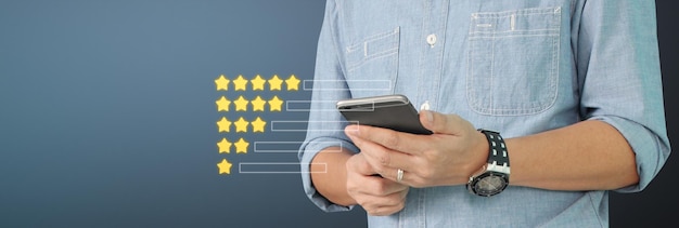 Man holding smartphone device and touching screen with five star rating feedback icon