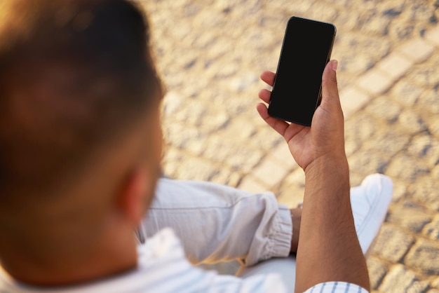 Man holding smartphone using mobile app shopping online on the street. E-commerce concept