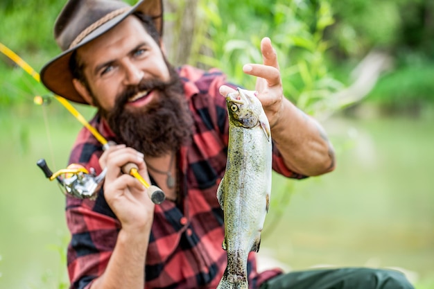 Man holding a trout fish Fishing Angler with fishing trophy Fisherman and trout Fishing backgrounds Man hold big fish trout in his hands Fisherman and trophy trout