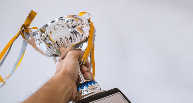 A man holding up a trophy cup