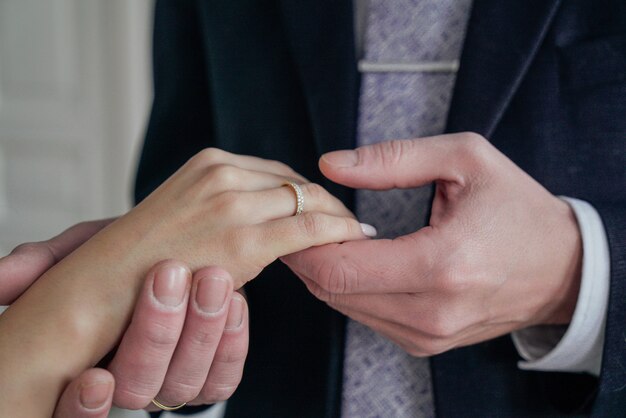 Man holding woman's hand with engagement ring