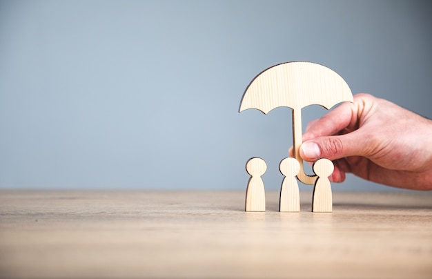 man holding wooden family and umbrella sign