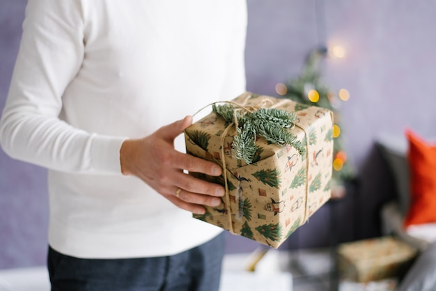 A man holds a Christmas or New Year gift in his hands.