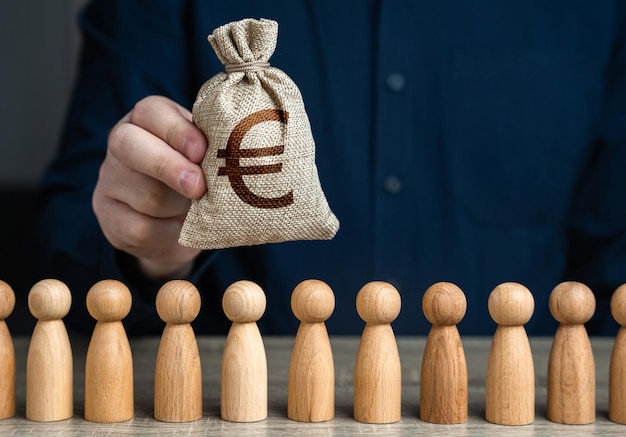 Photo a man holds a euro money bag above the crowd deposits and loans salaries crowdfunding and fundraising budgetary funds for social policy social politics