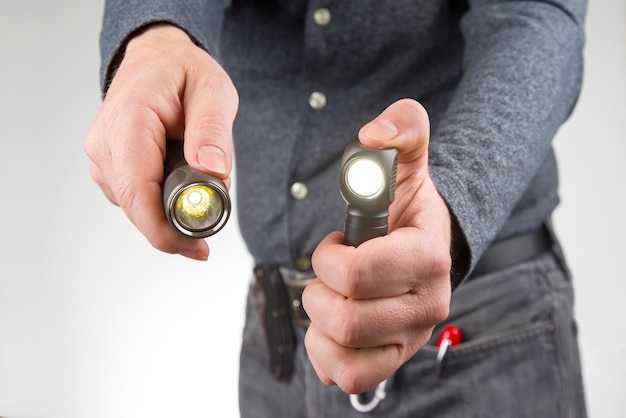 Man holds a flashlight in his hand item for camping and household life