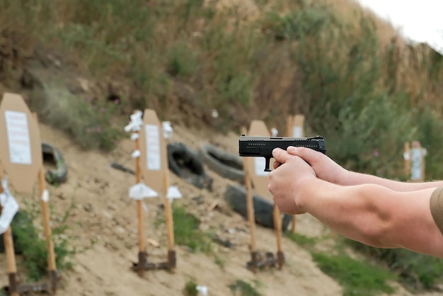 A man holds a gun in his hands pistol shooting exercises