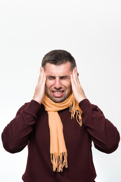 A man holds his hand on his head because of a headache portrait of a man on a white background