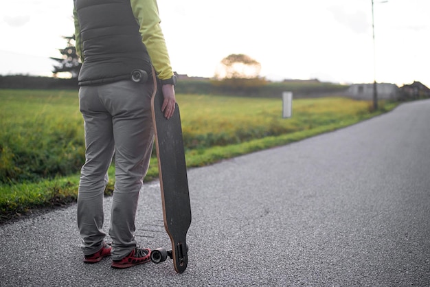 A man holds his longboard and prepares to ride