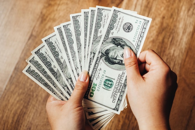 a man holds hundreds of dollars