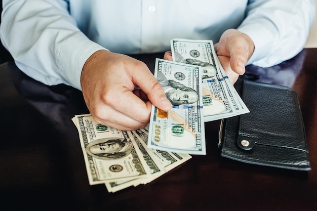 a man holds hundreds of dollars