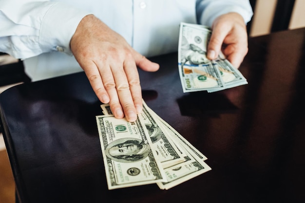 a man holds hundreds of dollars