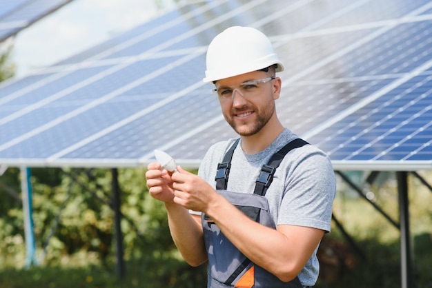 A man holds an Incandescent light bulb in his energy concept the sun is clean after work and replaces the energy that produces carbon dioxide