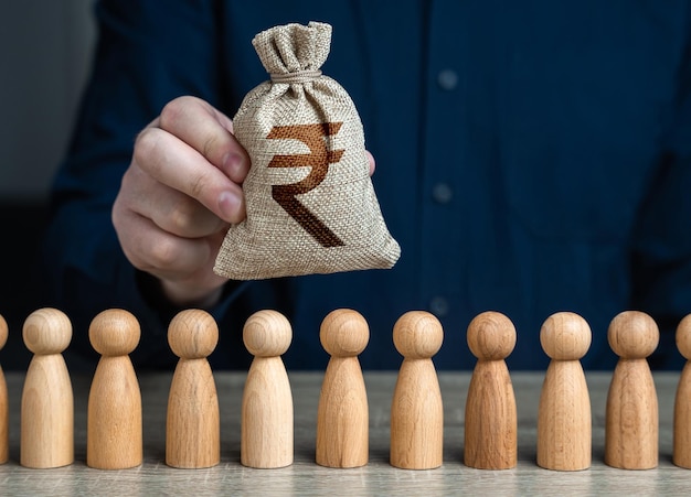 Photo a man holds a indian rupee money bag above the crowdsalaries crowdfunding and fundraising social politics deposits and loans budgetary funds for social policy