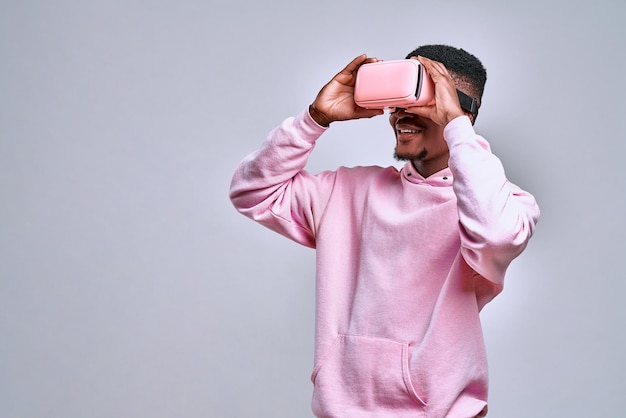 man holds pink virtual glasses and enjoys what he sees The concept of fun technology virtual reality