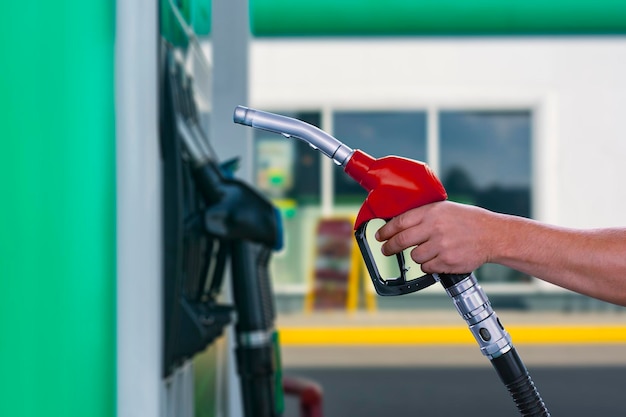 Man holds a refueling gun in his hand for refueling cars Gas station with diesel and gasoline fuel closeup