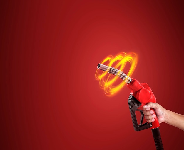 Man holds a refueling gun in his hand for refueling cars isolated on red background