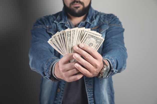 Man holds wads of money and shows