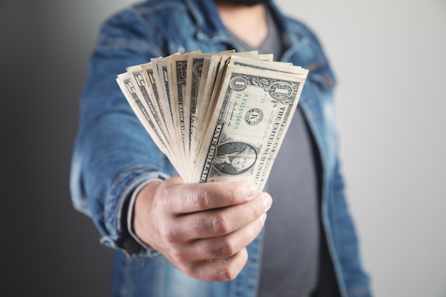 Man holds wads of money and shows