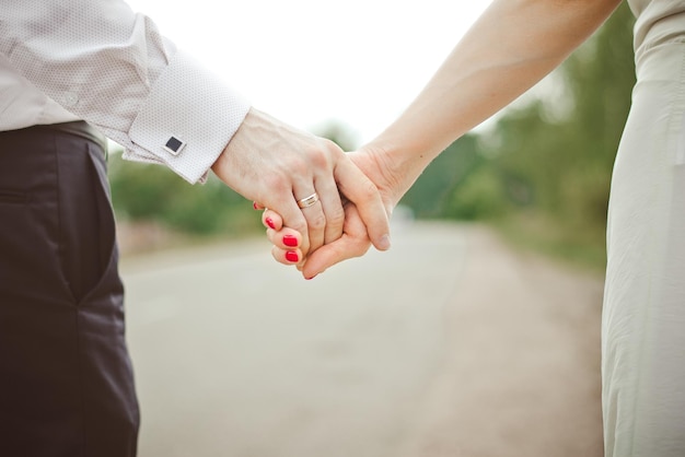 A man holds a woman's hand Hands of the bride and groom with a wedding ring closeup