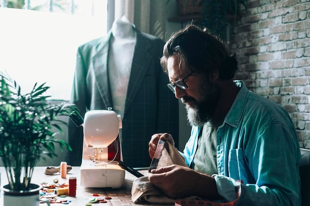 Man at home using sewing machine to tailor and modify garments Blazer in background Tailoring and tailor at work at the workshop Concept of people and alternative job for woman Professional tailor