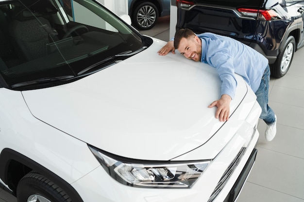 Man hugging his new car