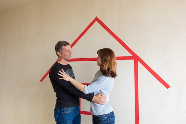 Man hugging his wife. Young couple moving in new apartmen. View from side. Concept new homes, new