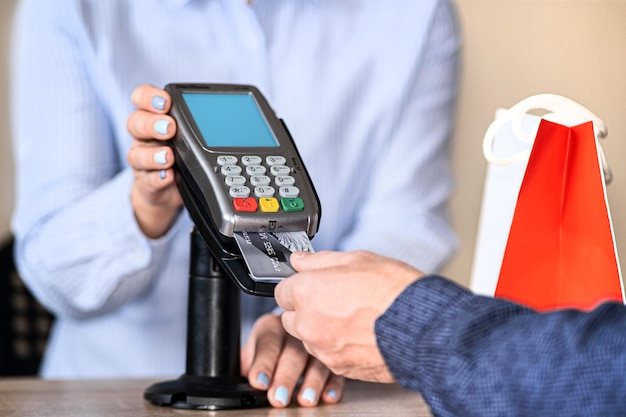 The man inserted a plastic card into the payment terminal Conducts payment for the purchase