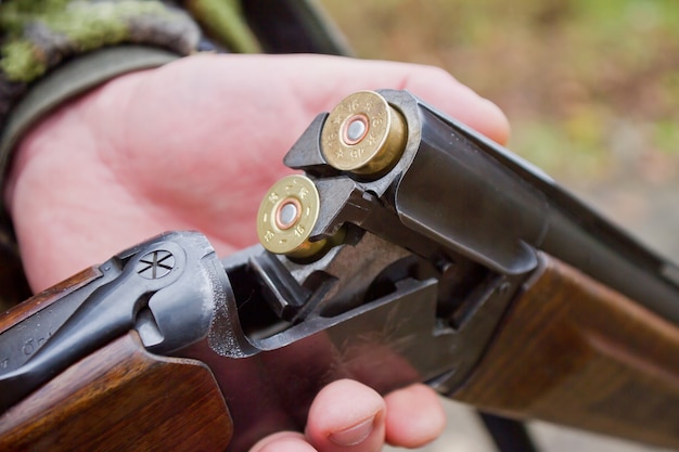 man inserting bullets into a shotgun