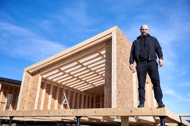 Man inspecting quality of building wooden frame house