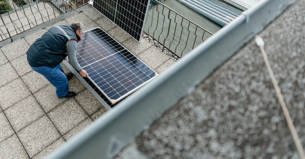 Man installing solar photovoltaic panel system in family house alternative energy concept high quali