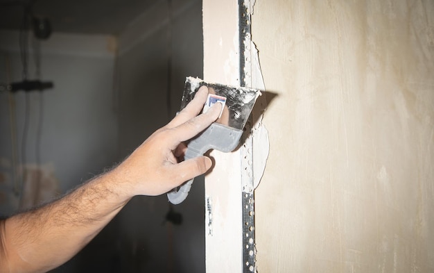 Man is applying putty on a wall Renovating house