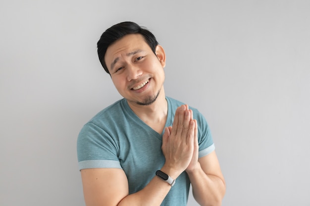 Man is begging for something on grey background.