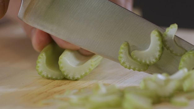 Man is cutting a celery in the kitchen