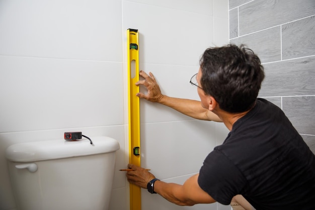 A man is doing repairs in the bathroom