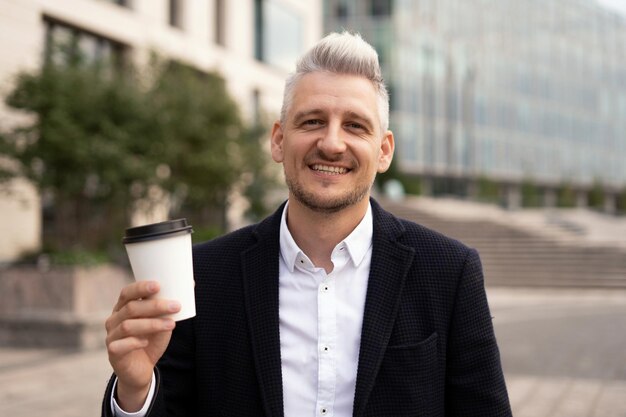 The man is a grayhaired financier in a jacket The economist is taking a break for lunch drinking