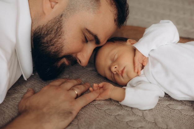 a man is holding a baby and the baby is wearing a white shirt